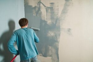 Professional painter applying high-quality interior paint to a residential wall for a smooth and durable finish
