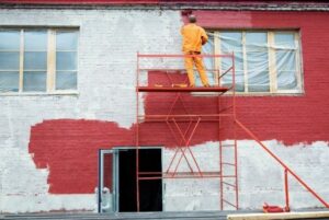 Commercial building receiving professional painting services to improve exterior appearance and structural protection