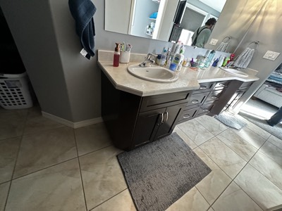 Dark painted bathroom vanity with grey countertop and modern fixtures