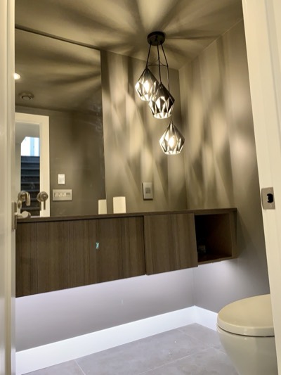 Modern powder room with pendant lighting and crisp painted walls