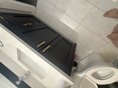 Navy blue painted vanity with gold hardware and marble countertop