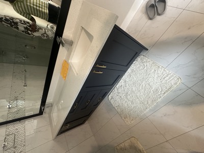 Navy painted vanity paired with glass shower enclosure and tile work