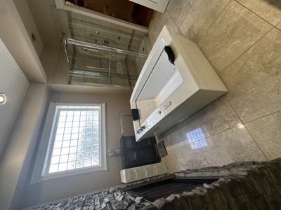 Stone accent wall bathroom with freestanding tub and neutral painted surfaces