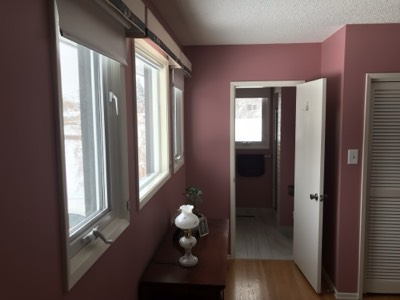 Pink and mauve painted bedroom viewed through a freshly painted doorway