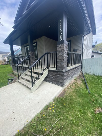 Dark charcoal painted exterior with natural stone veneer accents