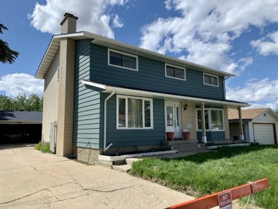 Teal painted exterior with exposed brick accent wall and updated trim