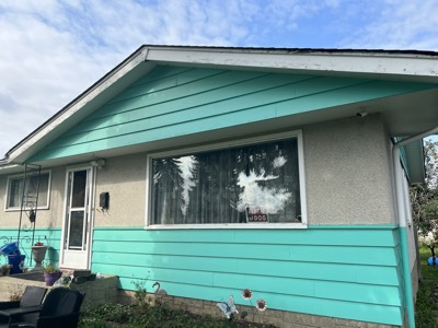 Bold teal and turquoise painted house exterior with white trim accents