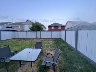 Freshly painted white fence in a landscaped Edmonton backyard