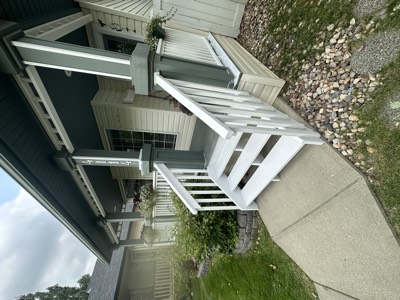 White painted porch contrasting with dark house siding and stone accents
