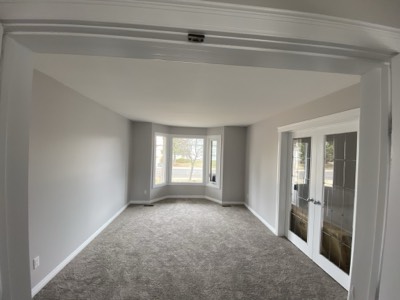 Grey painted hallway with bay window seat and natural light throughout