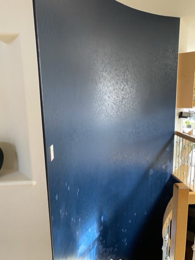 Navy accent wall in a stairwell with white painted railing and treads