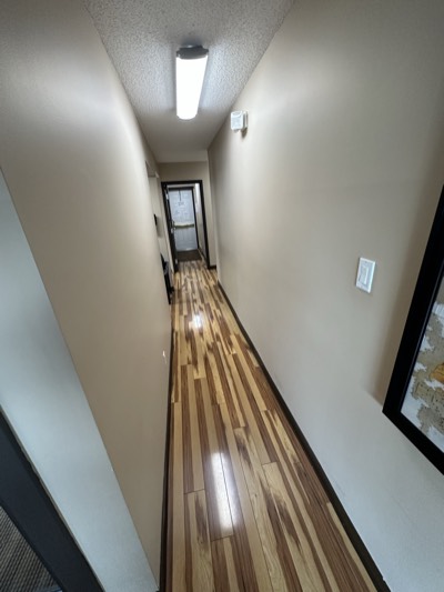Residential hallway with hardwood floors and freshly painted walls and trim