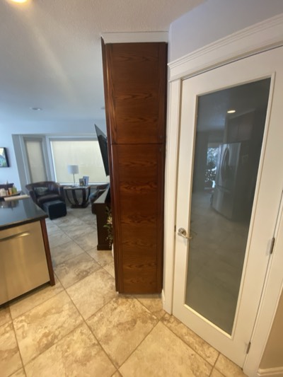 Hallway with stained decorative column and glass railing on upper level