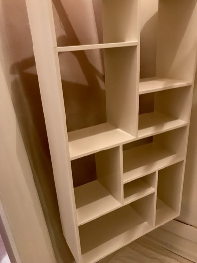 Custom painted shelving built into staircase wall with organized display