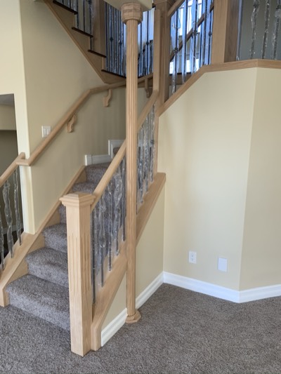 Oak stained railing with iron balusters and freshly painted stair stringers