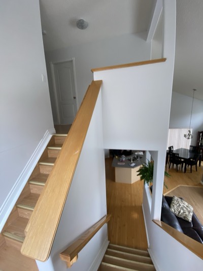 White painted staircase with oak treads in a bright and airy entryway