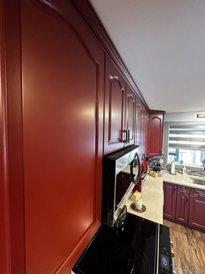 Cherry red stained kitchen cabinets with warm wood tones and recessed lighting