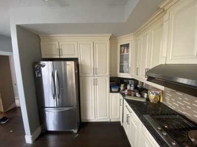 Cream painted kitchen with granite countertops and warm under-cabinet lighting