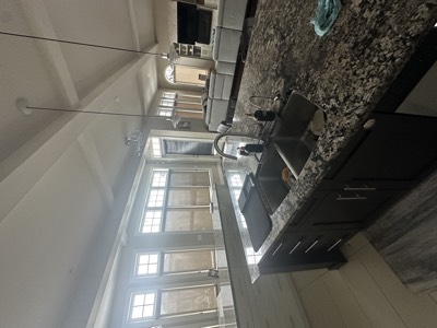 Dark painted cabinets in a bright kitchen with natural light and white walls