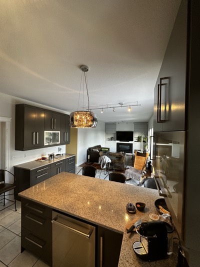 Dark grey painted kitchen with statement chandelier and elegant island seating