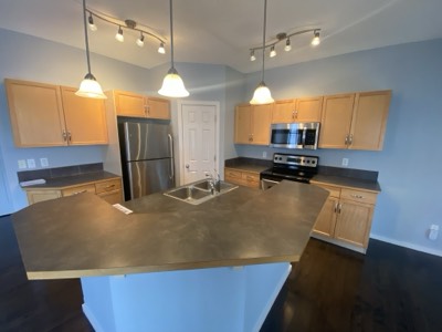 Maple stained cabinets with blue painted walls and modern hardware