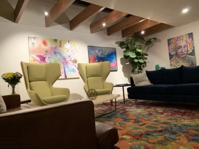 Designer living room with exposed beams, art display, and custom painted walls