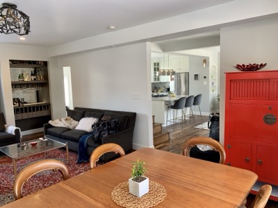 Dining room with bold red painted accent cabinet and neutral wall colour
