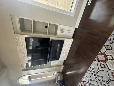 Entertainment wall with stone surround and freshly painted custom cabinetry