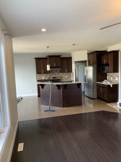 Open concept living area with dark painted kitchen cabinets and modern flow