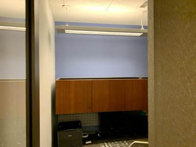 Office cubicle area with blue painted accent wall and energizing colour