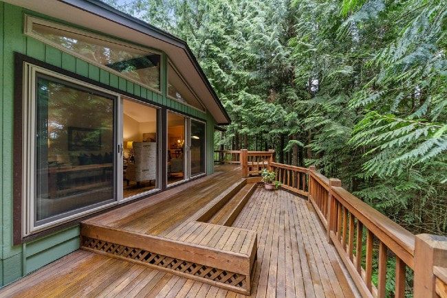 Wooden deck and railing on a forested home