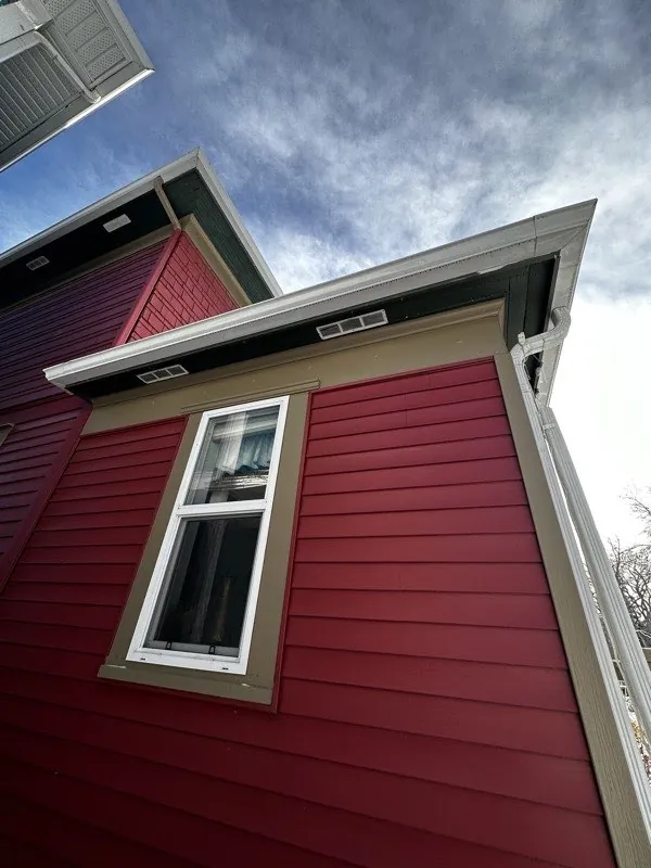 Exterior house painting by iPaint Painting — red siding with white trim in Edmonton