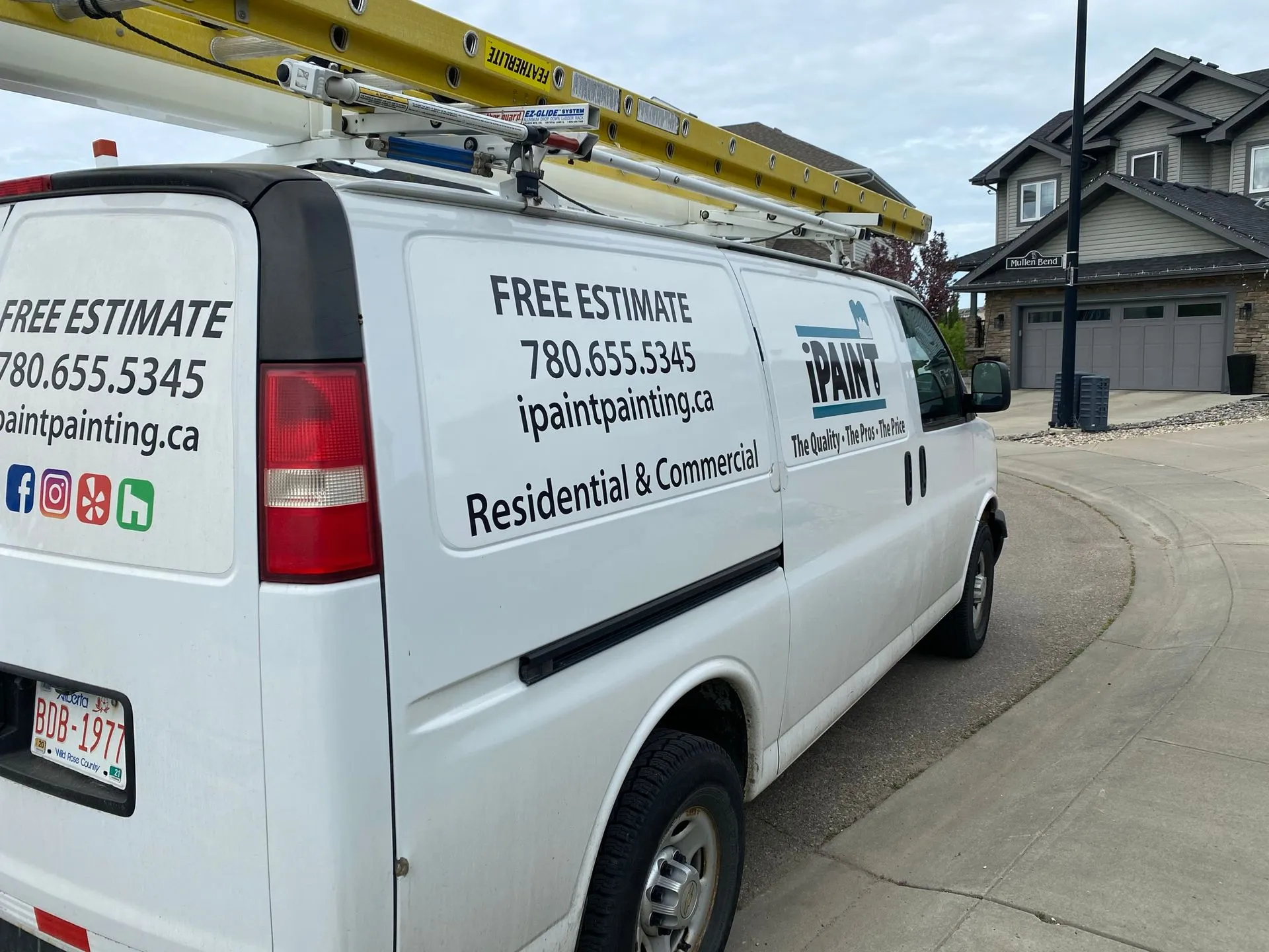 iPaint Painting branded work van with ladder rack in an Edmonton neighbourhood