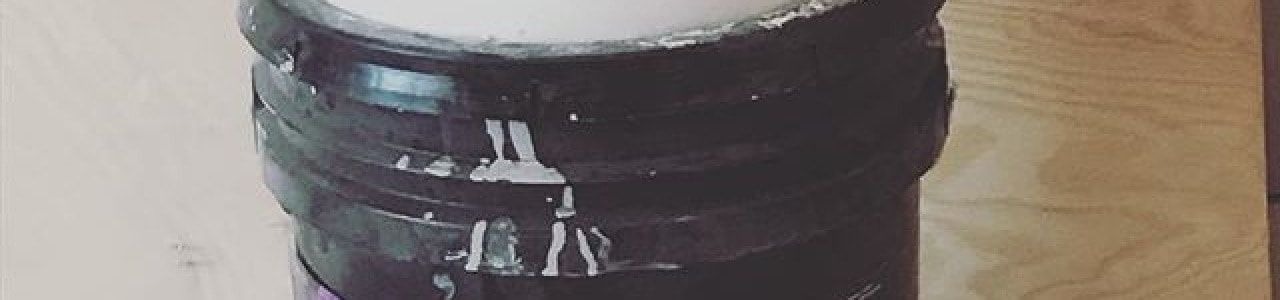 Painter adding paint conditioner to improve flow, leveling, and workability during an interior painting project